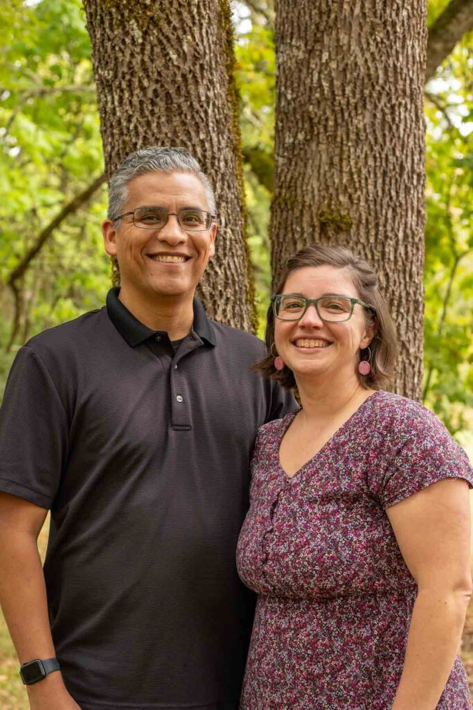 A couple standing in front of a tree.