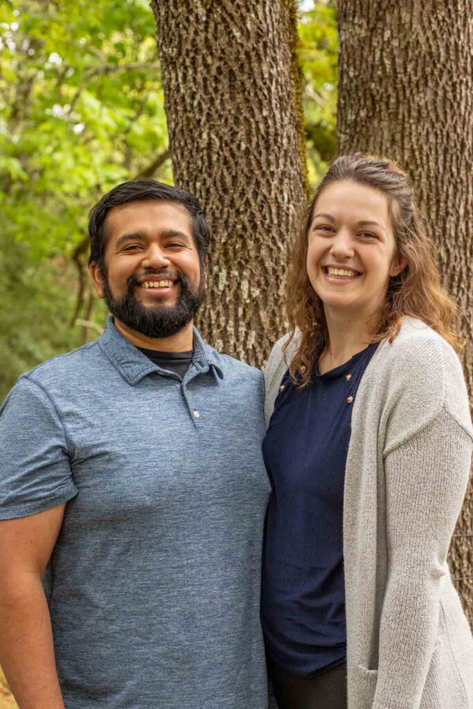 A couple standing in front of a tree.