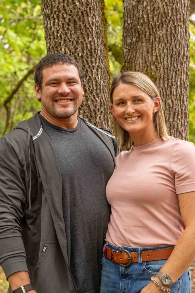 A couple standing in front of a tree.
